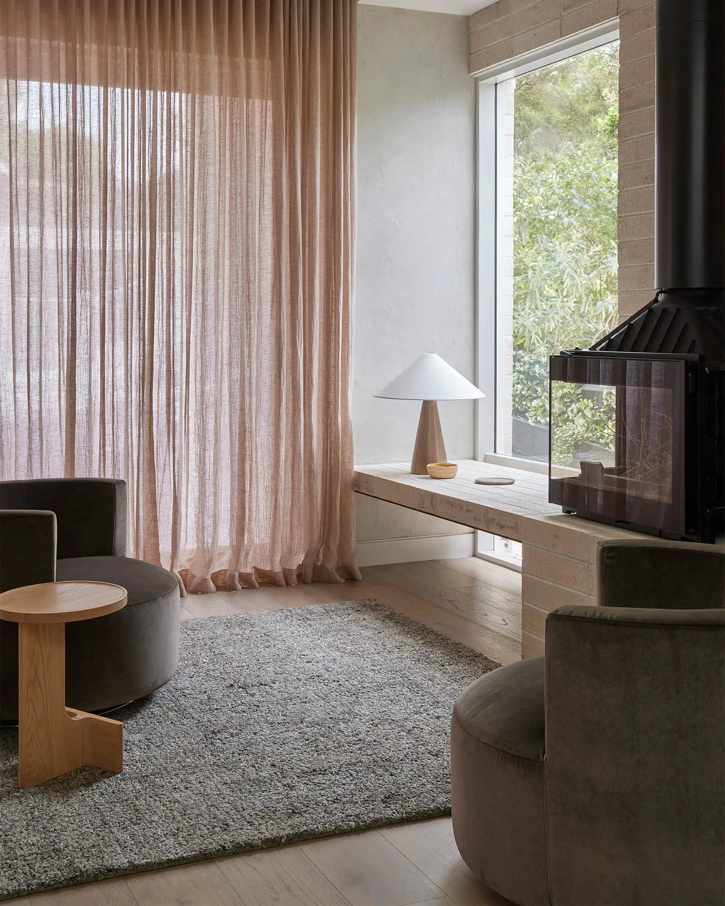 Modern living room with a fireplace, curtains, and furniture.